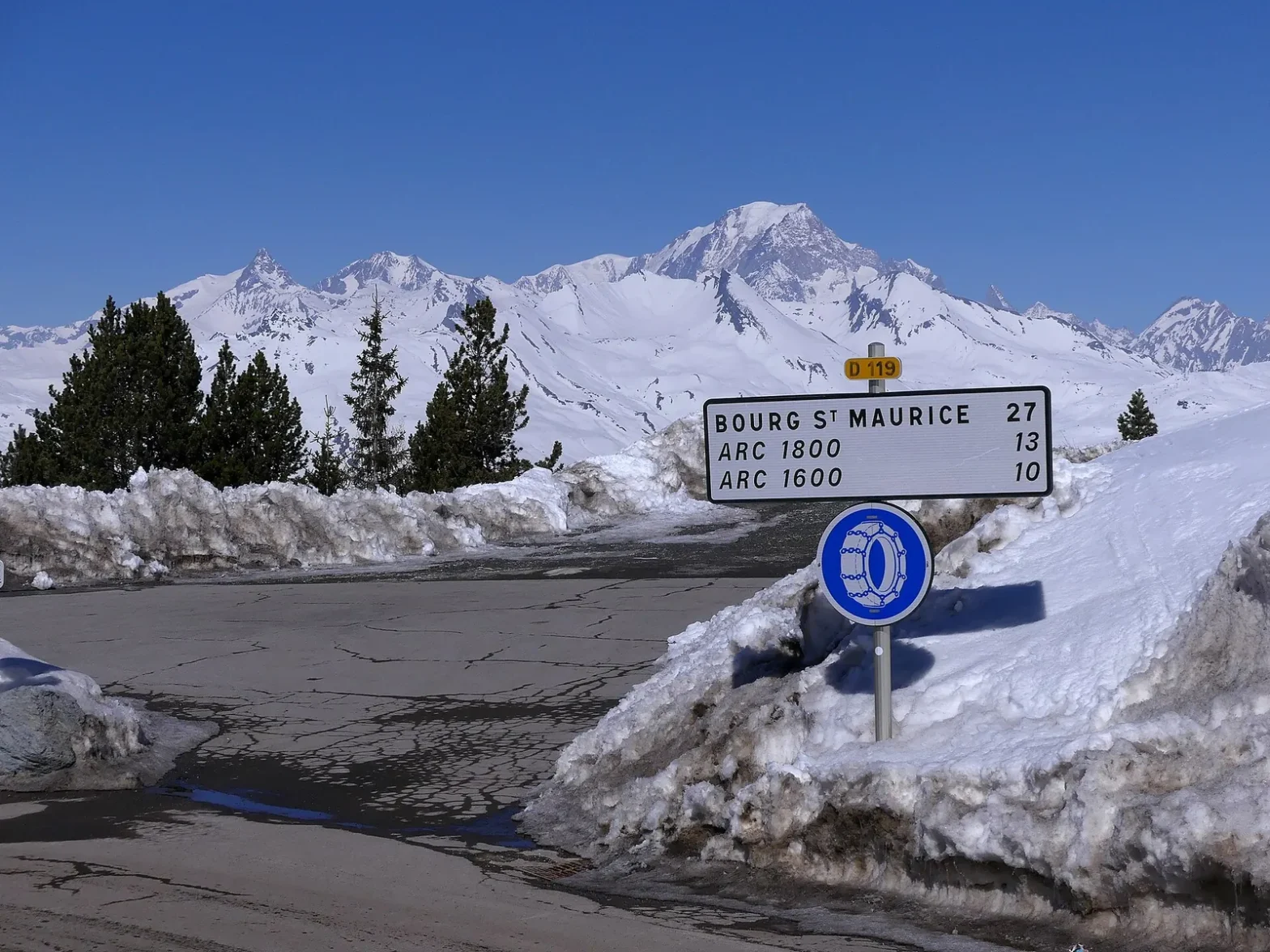 Route des Arcs enneigée au départ d'Arc 2000, panneau vers Bourg-Saint-Maurice, Arc 1800 et Arc 1600, Mont-Blanc en arrière-plan